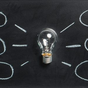 A lightbulb on a chalkboard symbolizes creativity, innovation, and ideas.